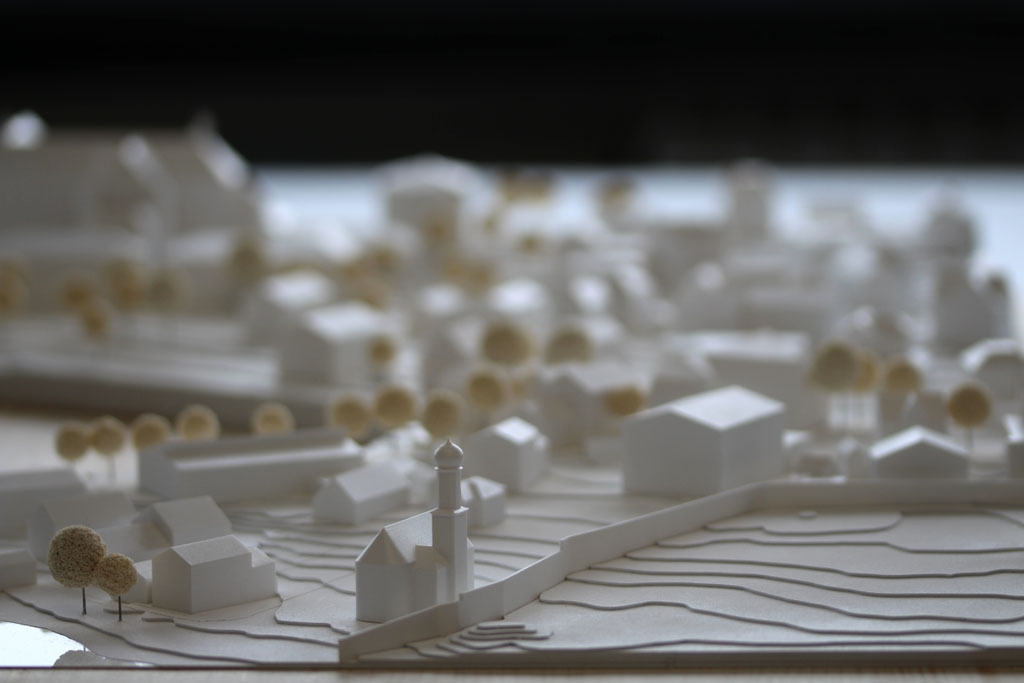 Weißes Massenmodell von der Umgebung des Gymnasiums in Tutzing auf einer Holzgrundplatte. Das Grundstück des Gymnasiums ist für eine entsprechende Einsatzplatte ausgespart.