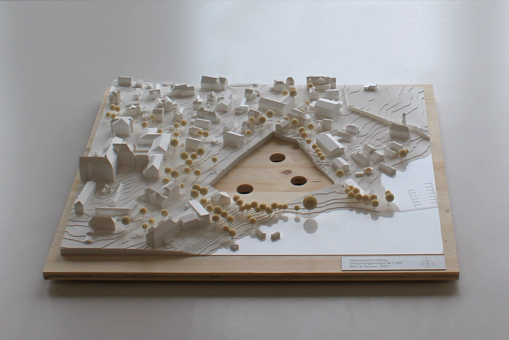 Weißes Massenmodell von der Umgebung des Gymnasiums in Tutzing auf einer Holzgrundplatte. Das Grundstück des Gymnasiums ist für eine entsprechende Einsatzplatte ausgespart.