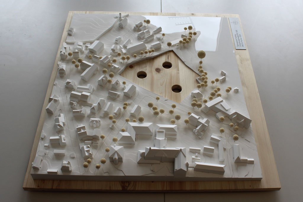 Weißes Massenmodell von der Umgebung des Gymnasiums in Tutzing auf einer Holzgrundplatte. Das Grundstück des Gymnasiums ist für eine entsprechende Einsatzplatte ausgespart.