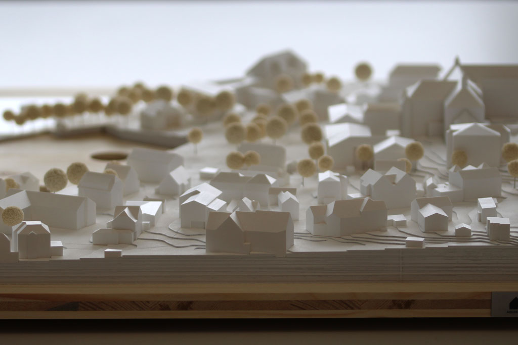 Weißes Massenmodell von der Umgebung des Gymnasiums in Tutzing auf einer Holzgrundplatte. Das Grundstück des Gymnasiums ist für eine entsprechende Einsatzplatte ausgespart.