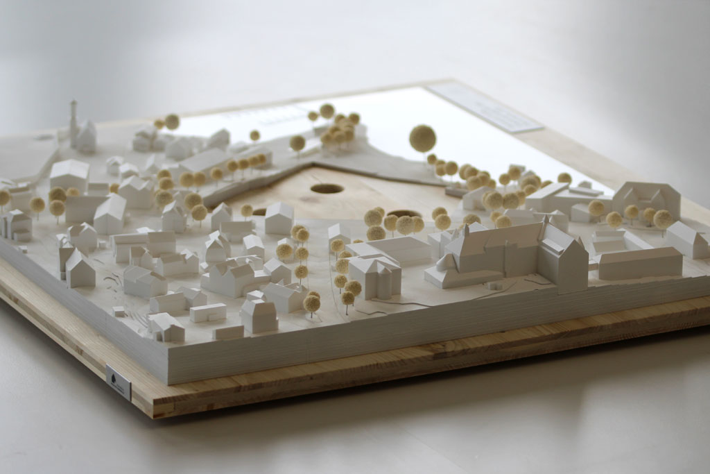 Weißes Massenmodell von der Umgebung des Gymnasiums in Tutzing auf einer Holzgrundplatte. Das Grundstück des Gymnasiums ist für eine entsprechende Einsatzplatte ausgespart.