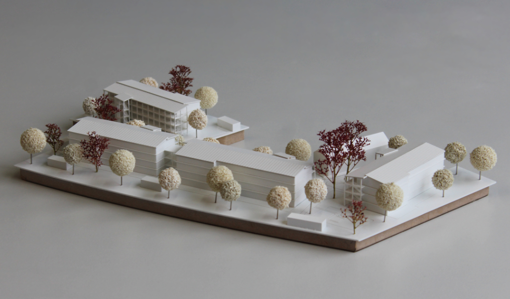 weißes Architekturmodell auf zwei Einsatzplatten mit insgesamt fünf Wohngebäuden.